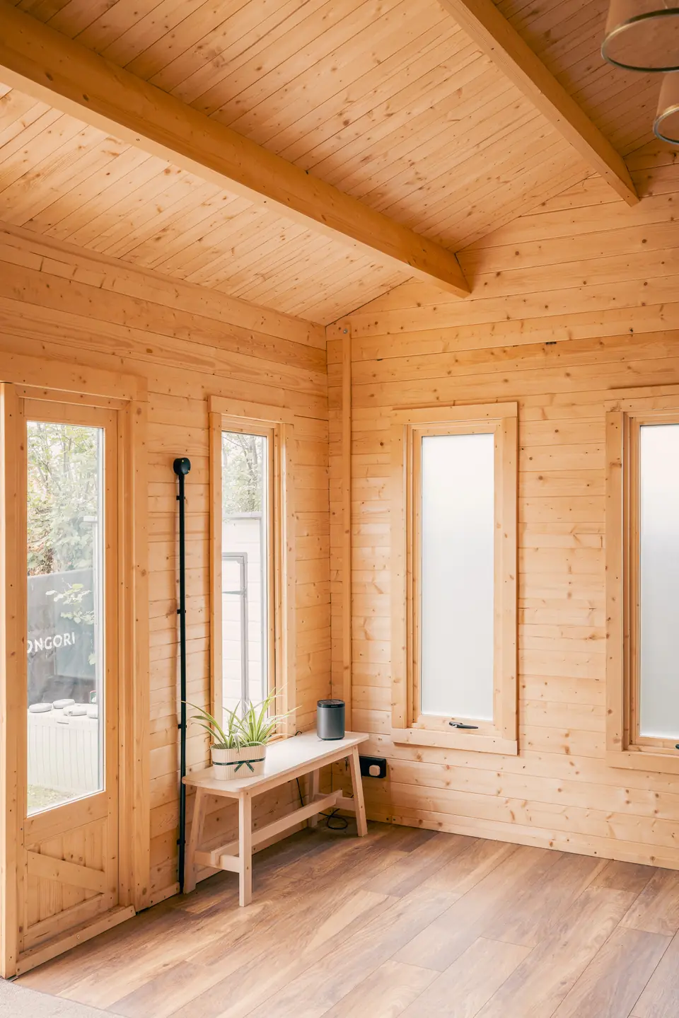 Corner of the pine garden room with tall glazed doors and a small side table
