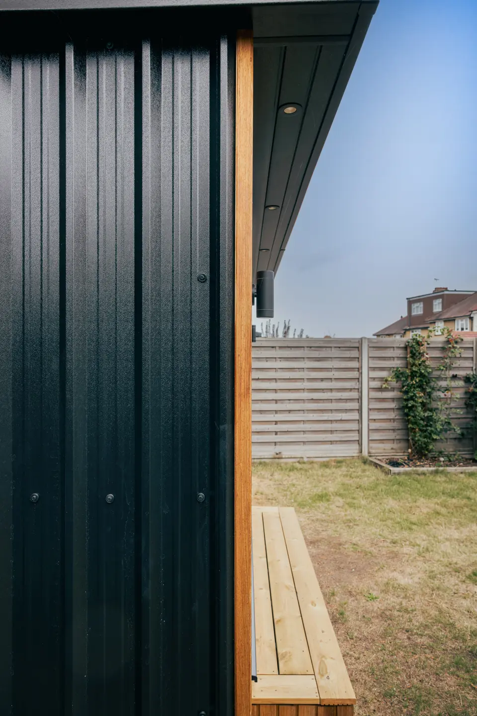 Downlights set into the soffit above the studio door, with a timber step below